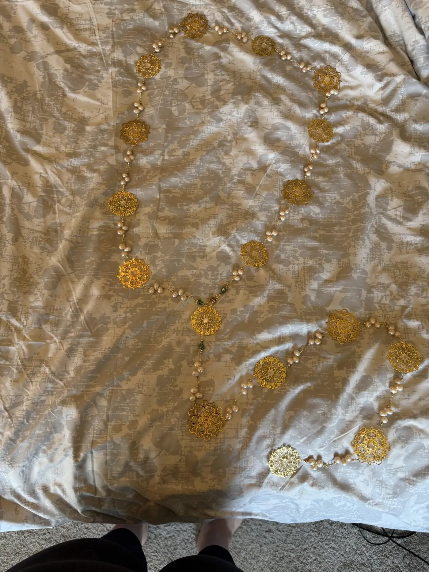 A gold-embroidered cloth with a chain of medallions, close up