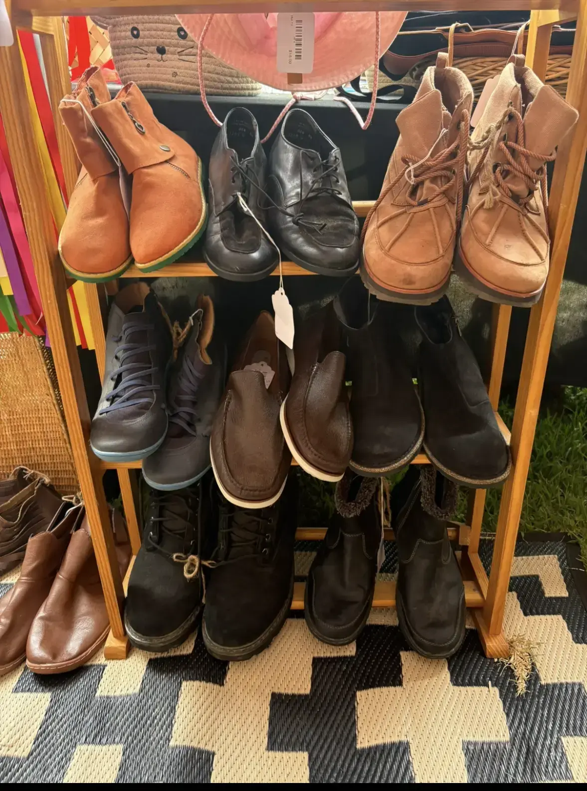 Leather boots and shoes on a wooden shoe rack at a costume stall