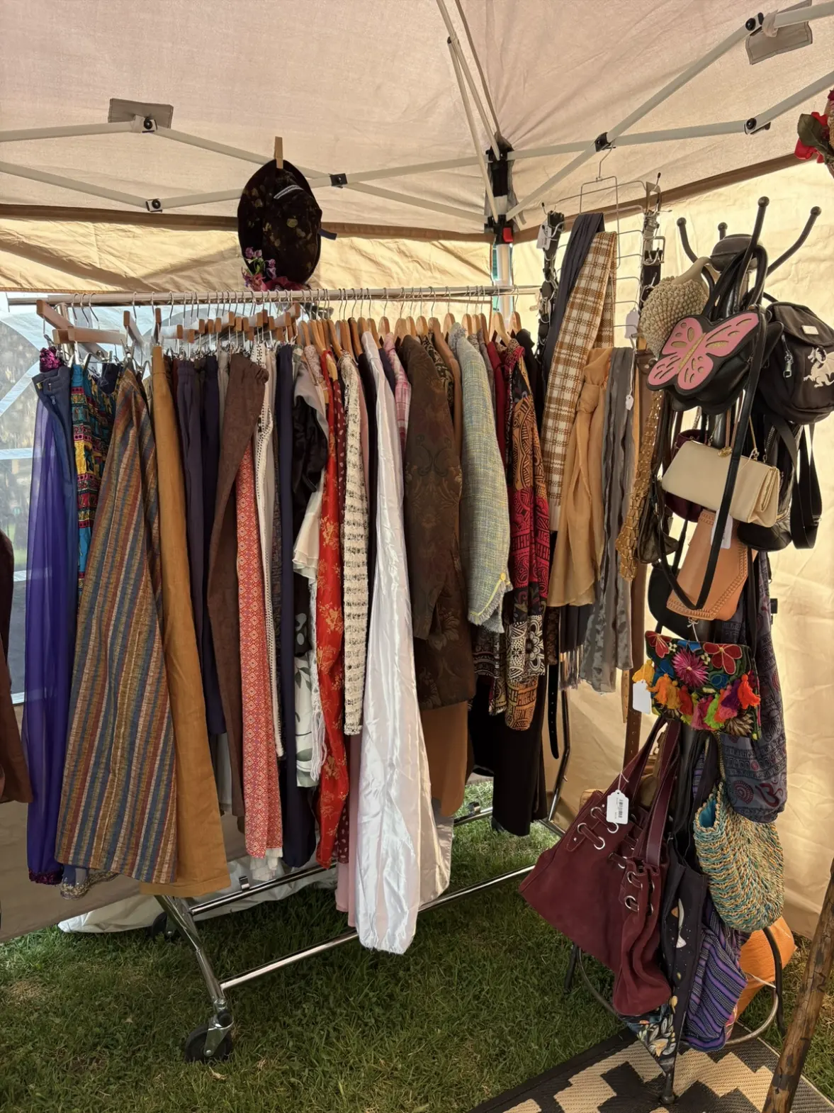 A rack of costume skirts, cloaks and hats under a vendor canopy