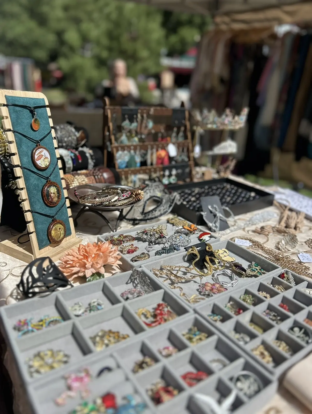 Trays of rings and charms on a jewelry table in the sun
